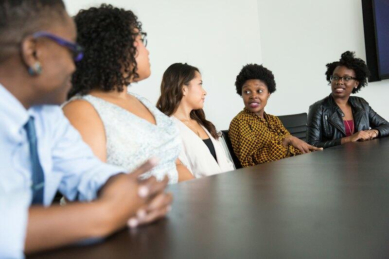 A diverse group of colleagues in discussion at a boardroom table