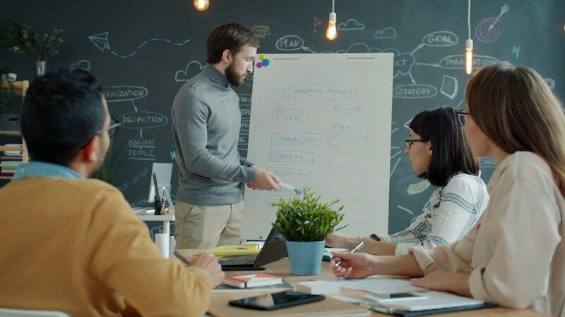 A facilitator running a training session at a whiteboard